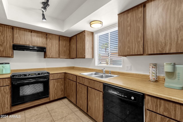 kitchen with range hood, light tile patterned floors, sink, black appliances, and a raised ceiling