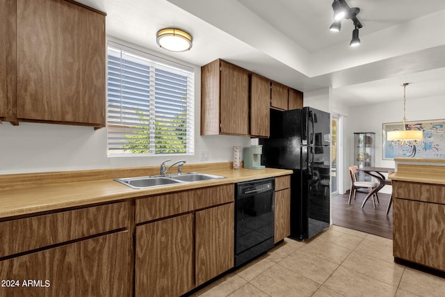 kitchen featuring black appliances, decorative light fixtures, sink, and light tile patterned floors