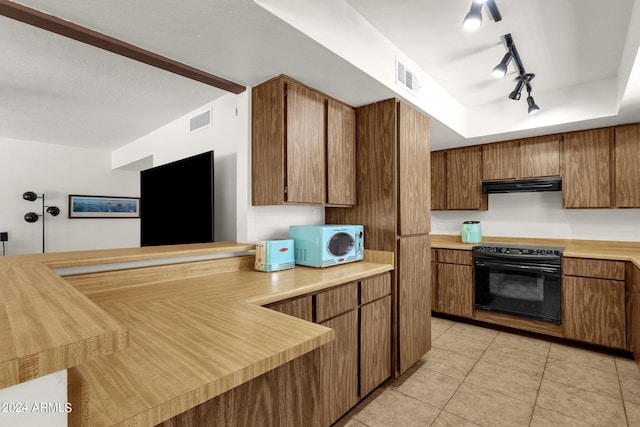 kitchen featuring light tile patterned floors, track lighting, black appliances, a raised ceiling, and kitchen peninsula