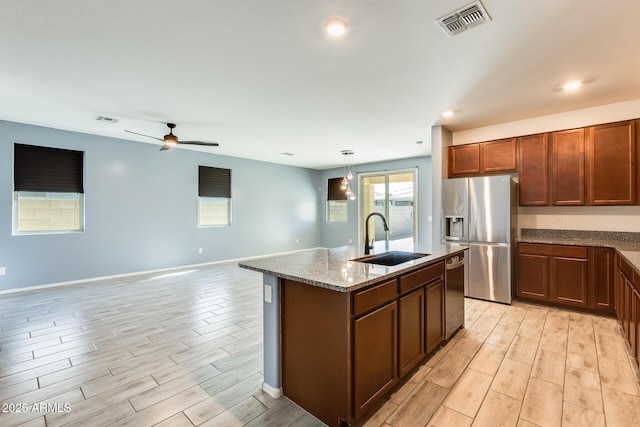 kitchen featuring appliances with stainless steel finishes, wood finish floors, a sink, and visible vents