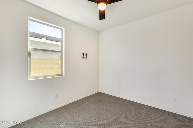 unfurnished room featuring dark carpet, a ceiling fan, and baseboards