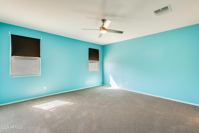 empty room featuring a ceiling fan, baseboards, visible vents, and carpet flooring