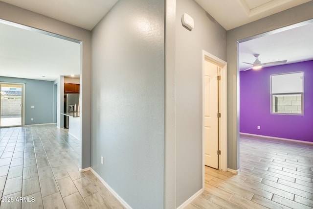 corridor with baseboards and wood finish floors