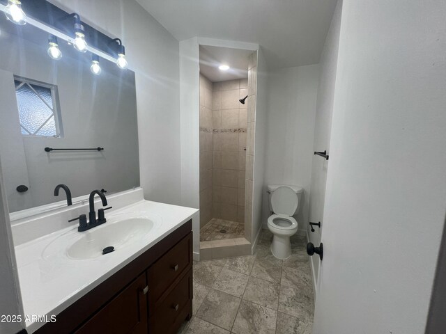 bathroom with toilet, a stall shower, and vanity