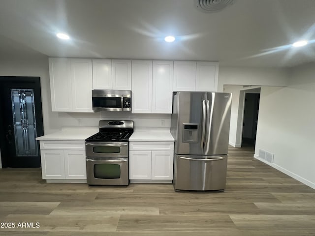 kitchen with light wood-style floors, visible vents, white cabinetry, and stainless steel appliances