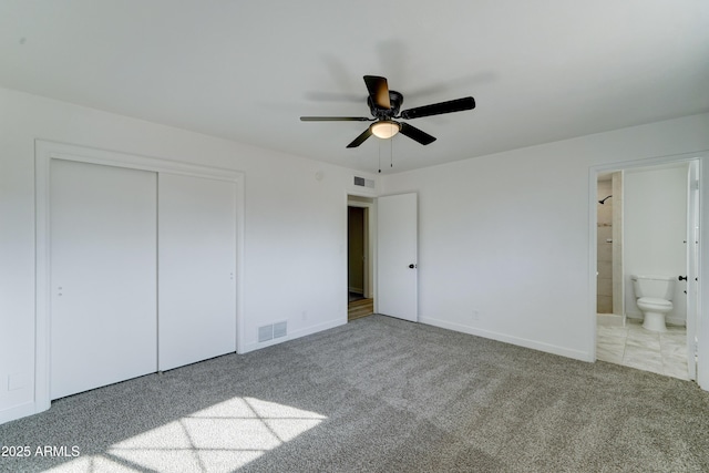 unfurnished bedroom featuring carpet floors, visible vents, a closet, and ensuite bathroom