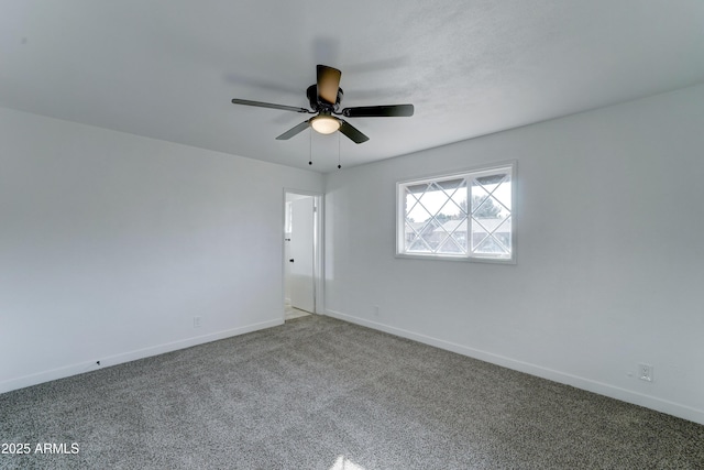 spare room featuring a ceiling fan, carpet, and baseboards