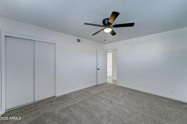 unfurnished bedroom featuring baseboards, visible vents, a ceiling fan, carpet flooring, and a closet