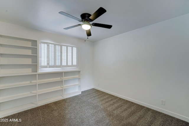 spare room with dark colored carpet, a ceiling fan, and baseboards