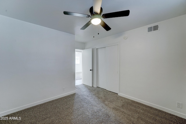 carpeted empty room featuring baseboards, visible vents, and ceiling fan