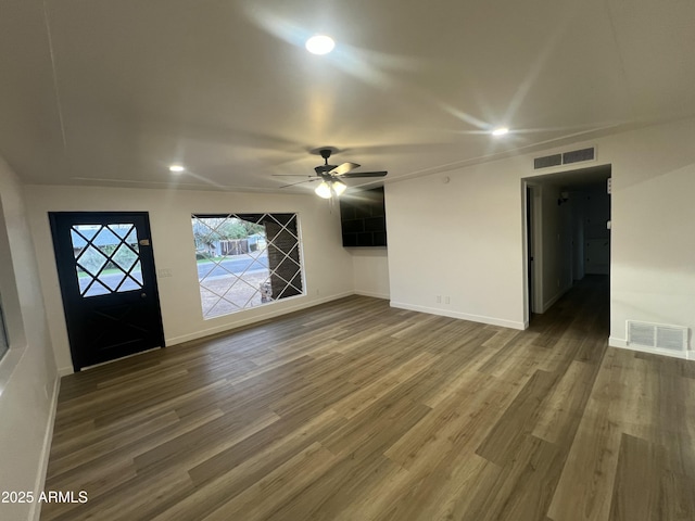 foyer with baseboards, visible vents, and wood finished floors