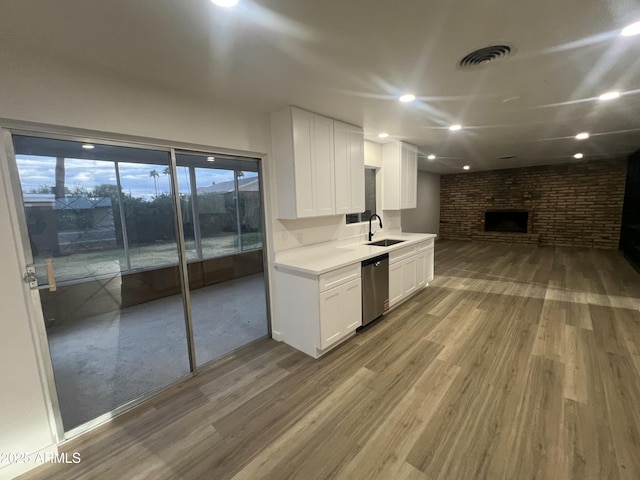 kitchen with visible vents, a sink, stainless steel dishwasher, and wood finished floors