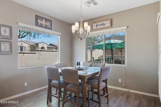 dining area with a chandelier and dark wood-type flooring