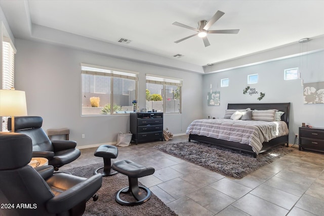 tiled bedroom with ceiling fan and multiple windows