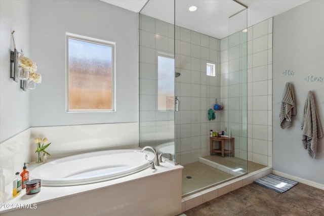 bathroom with tile flooring, a healthy amount of sunlight, and plus walk in shower