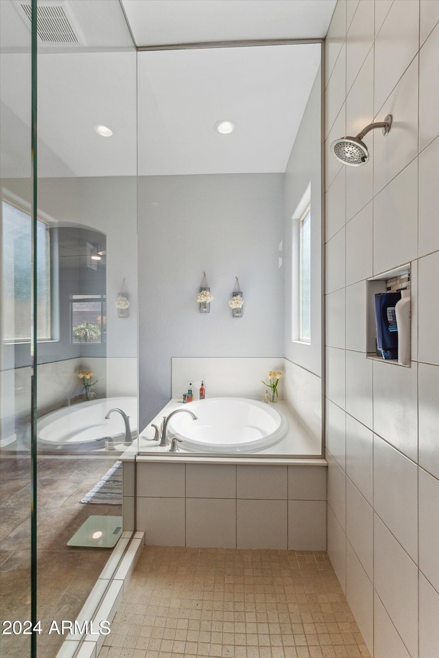 bathroom featuring tile walls, plus walk in shower, and tile floors