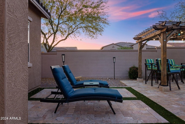 patio terrace at dusk featuring a pergola