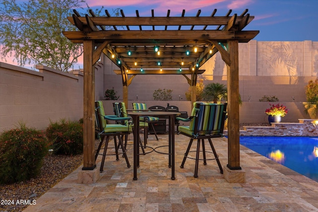 patio terrace at dusk with a fenced in pool and a pergola