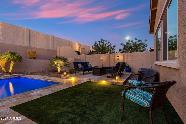 pool at dusk with a patio area, a yard, and outdoor lounge area