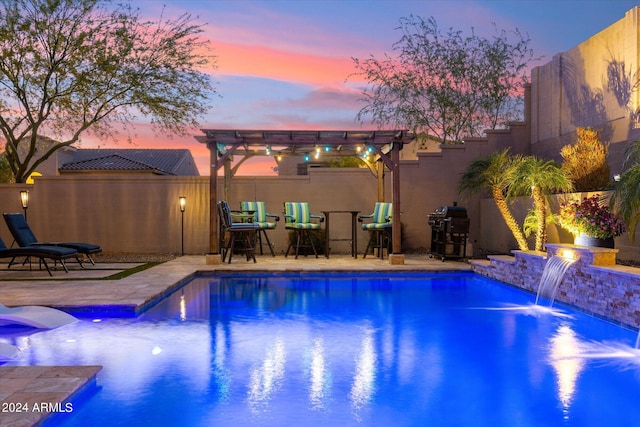 pool at dusk with area for grilling, a pergola, pool water feature, and a patio