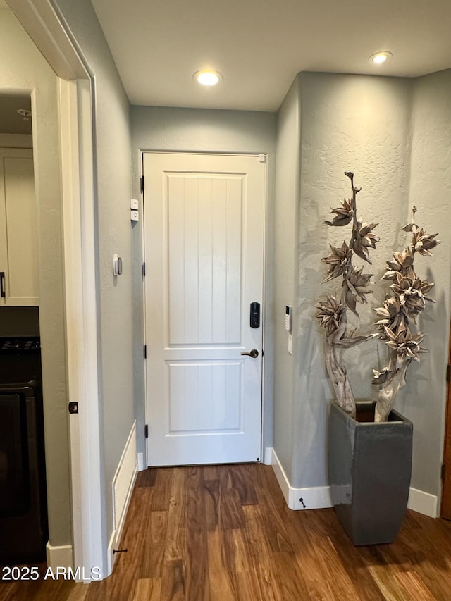 doorway with dark hardwood / wood-style floors and washer / dryer