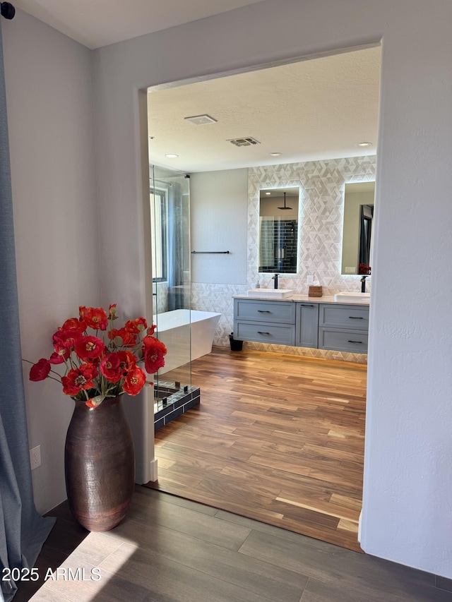 bathroom with a bathing tub, vanity, and hardwood / wood-style flooring