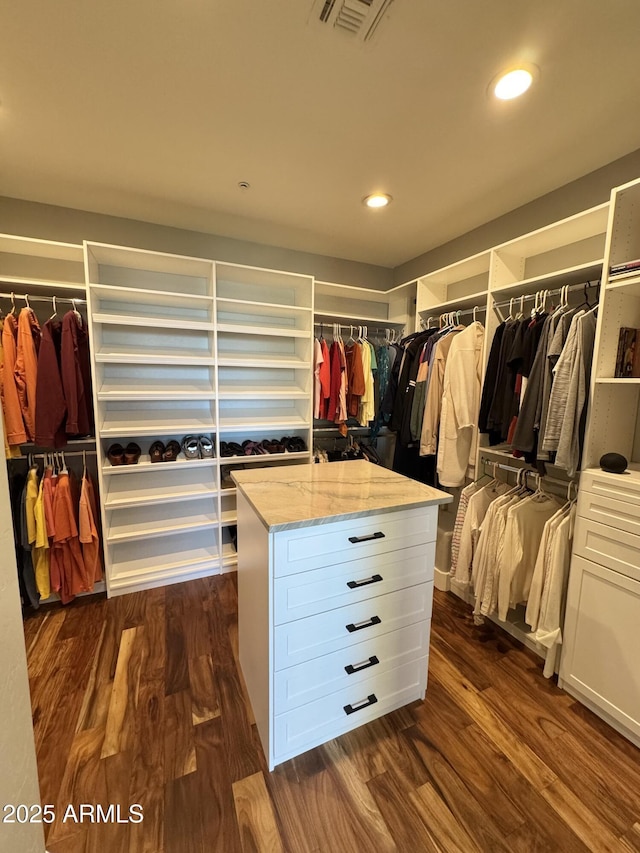 walk in closet with dark wood-type flooring