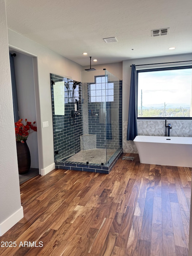 bathroom featuring independent shower and bath and hardwood / wood-style flooring