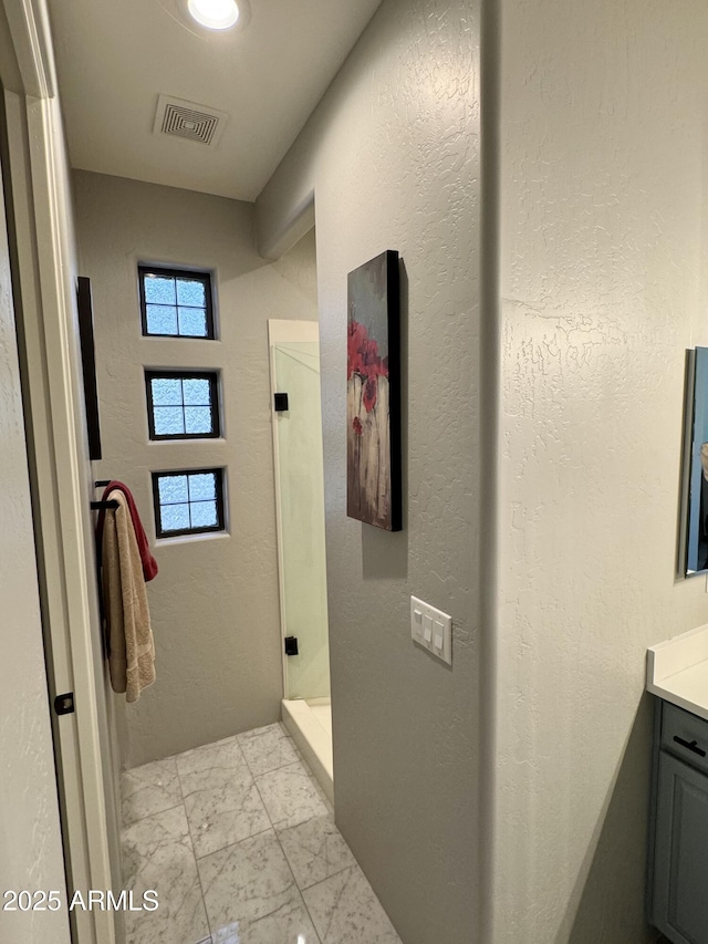 bathroom featuring a shower and vanity