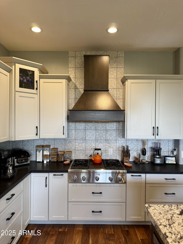 kitchen with decorative backsplash, white cabinetry, custom range hood, and stainless steel gas cooktop