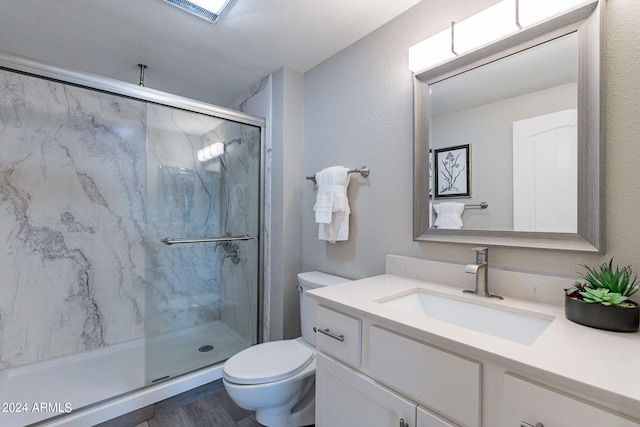 bathroom featuring a textured ceiling, vanity, toilet, and walk in shower