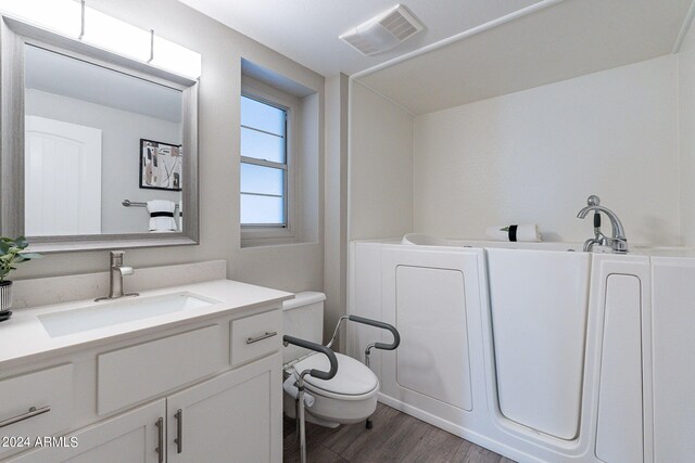 bathroom featuring vanity, toilet, and hardwood / wood-style flooring