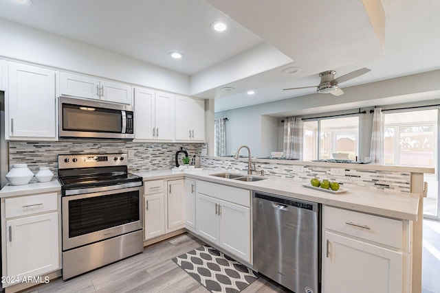 kitchen featuring light hardwood / wood-style flooring, appliances with stainless steel finishes, sink, white cabinetry, and ceiling fan