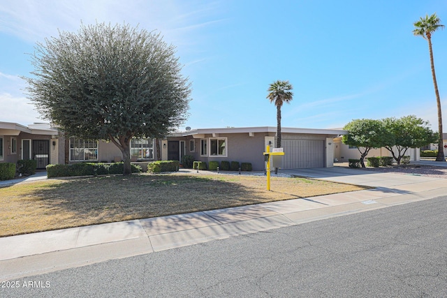 ranch-style home featuring a garage and a front lawn