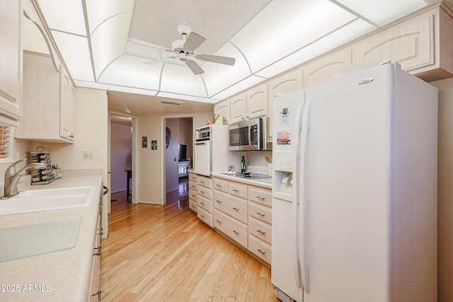 kitchen with sink, white fridge with ice dispenser, ceiling fan, light hardwood / wood-style floors, and black electric cooktop