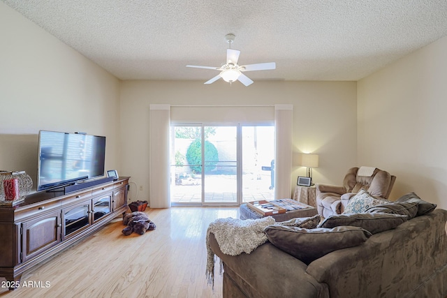 living room with ceiling fan, light hardwood / wood-style flooring, and a textured ceiling