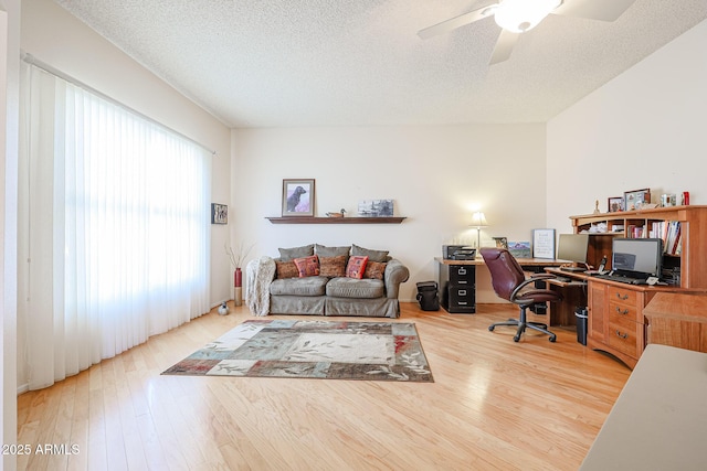 home office featuring ceiling fan, hardwood / wood-style flooring, and a textured ceiling