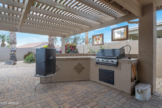 view of patio with area for grilling and a pergola