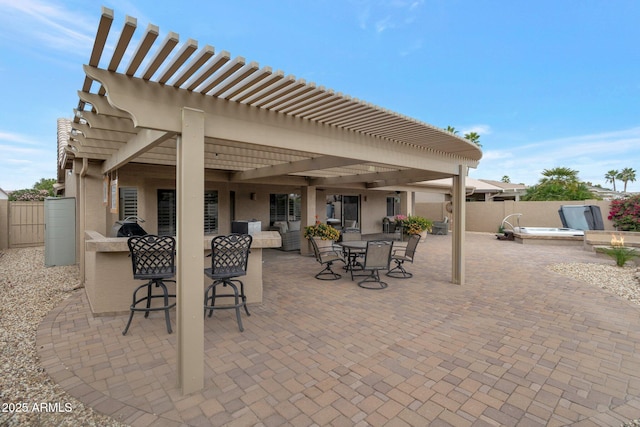 view of patio with an outdoor hot tub, a fenced backyard, a pergola, and outdoor dry bar