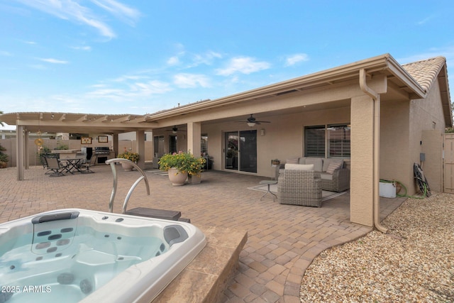 rear view of house featuring an outdoor hot tub, stucco siding, an outdoor hangout area, and a patio