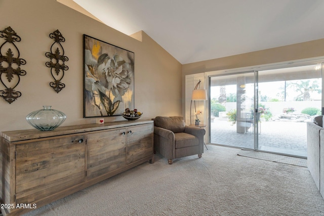 sitting room with lofted ceiling and carpet flooring