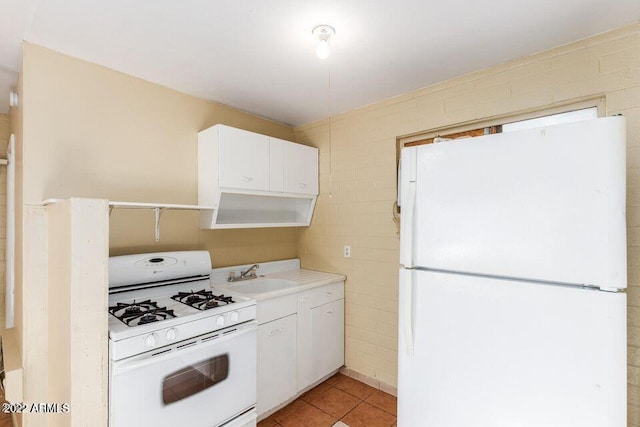 kitchen featuring white appliances, light tile patterned floors, light countertops, white cabinetry, and a sink