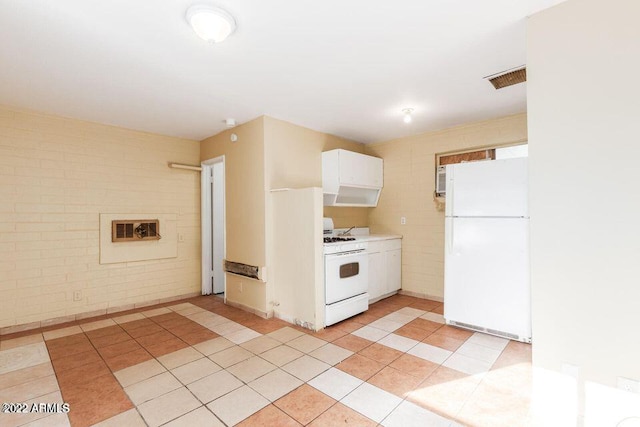 kitchen featuring light tile patterned floors, light countertops, white cabinets, brick wall, and white appliances