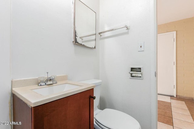 bathroom with toilet, vanity, and tile patterned floors