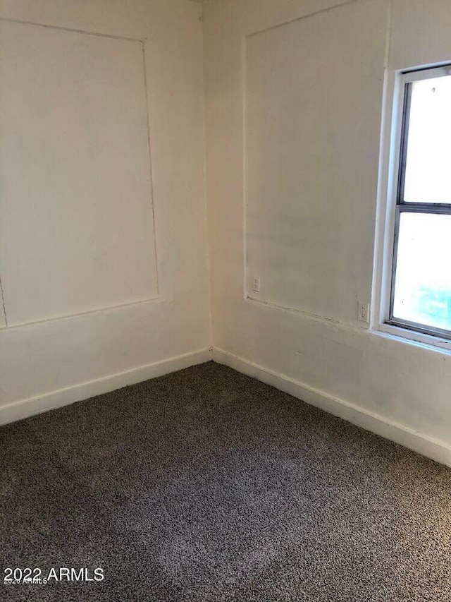 carpeted spare room with baseboards