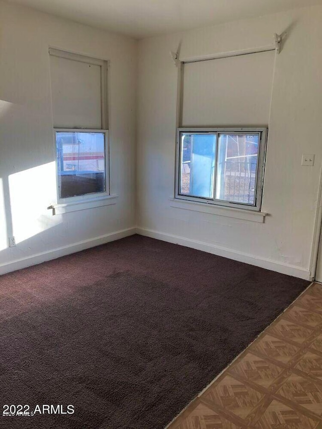 carpeted spare room featuring baseboards