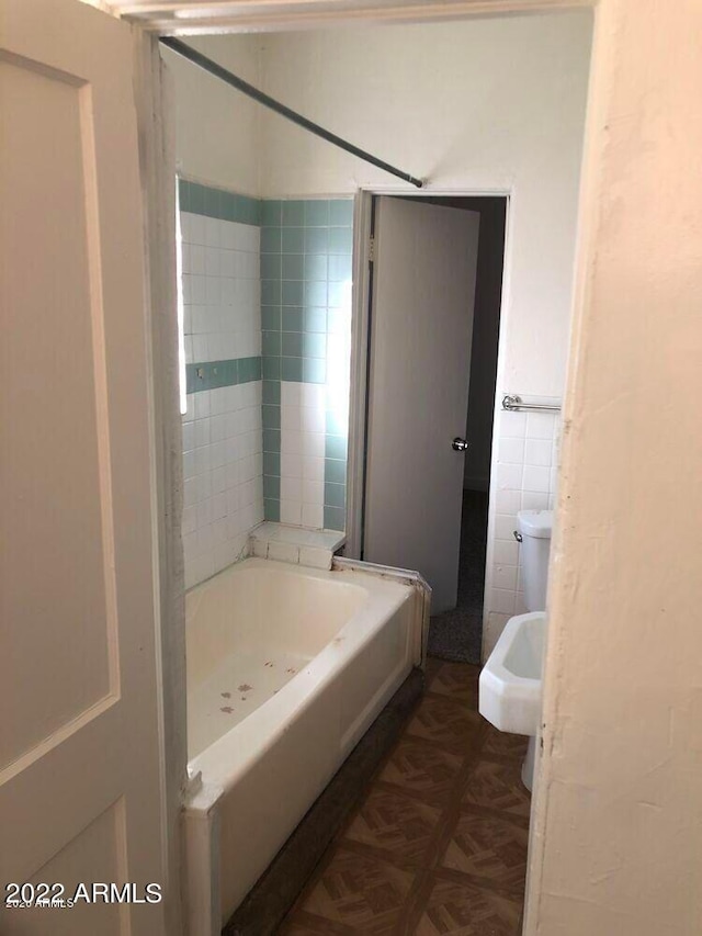 bathroom with a bath, a shower, and tile walls