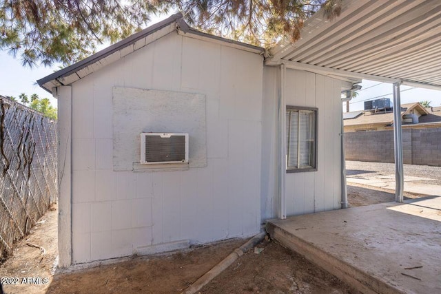 view of property exterior featuring an outbuilding, a patio area, and fence