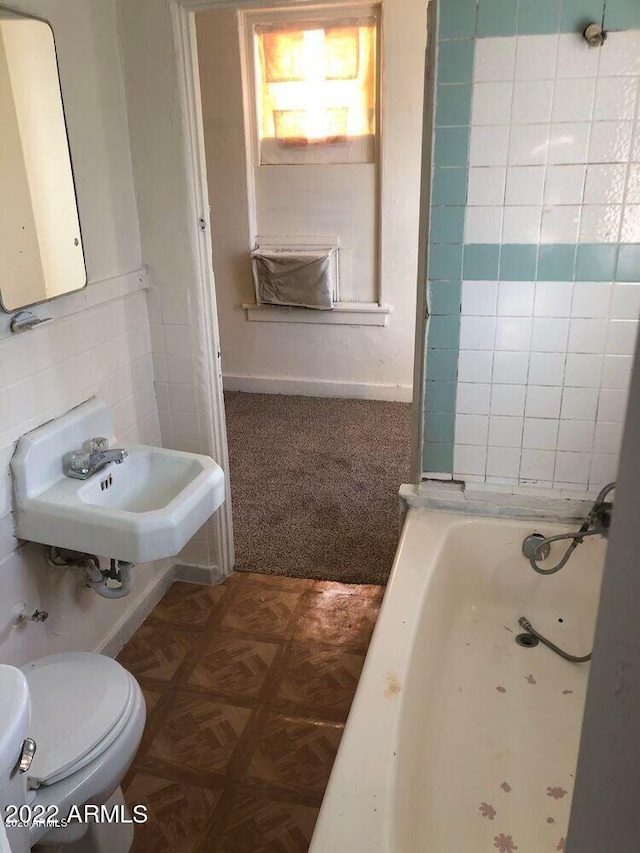 bathroom with toilet, a sink, and a bathing tub