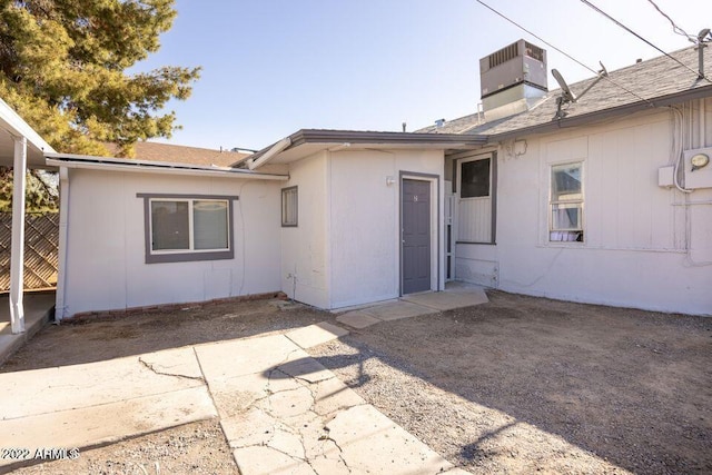 back of property featuring cooling unit, roof with shingles, a patio, and fence